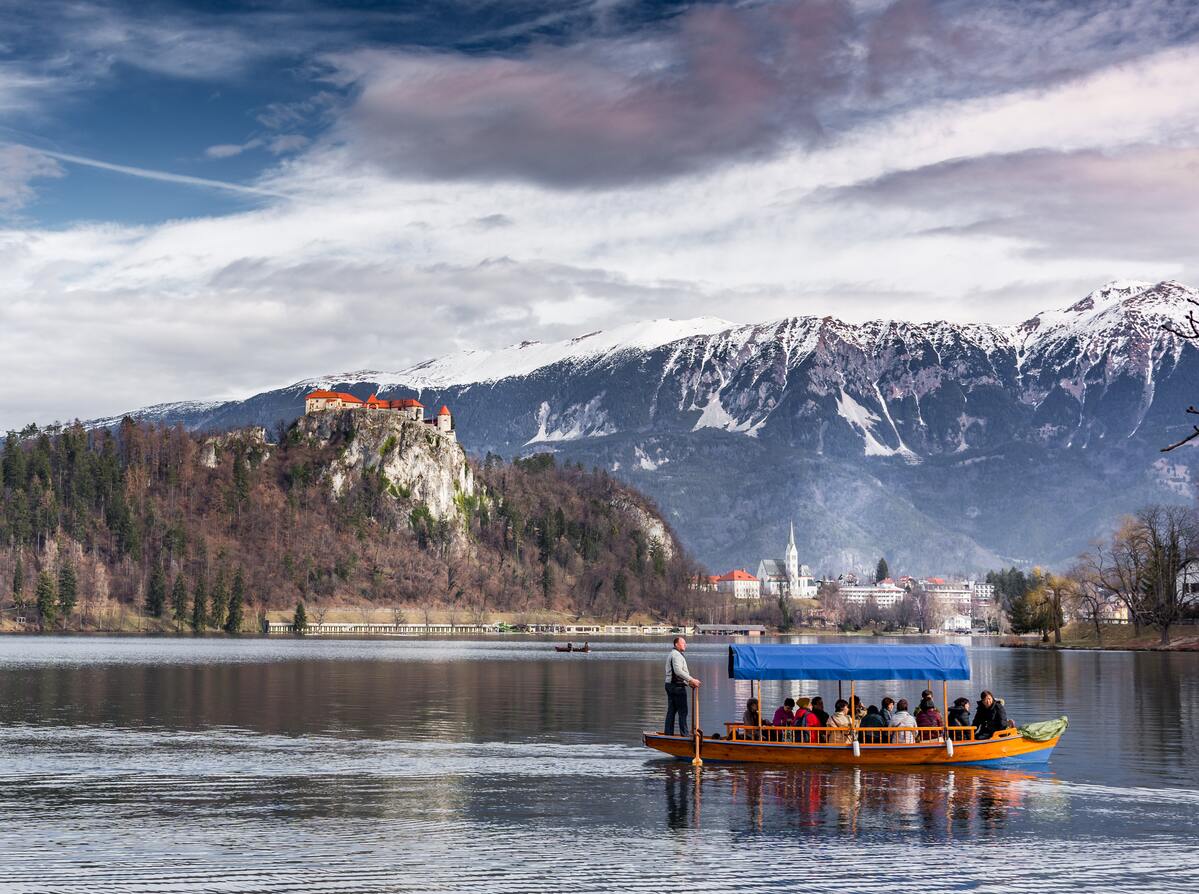 group of tourists on a boat ride with mountains in the distance